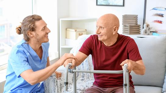 Man And Care Worker In Living Room Zimmer Frame