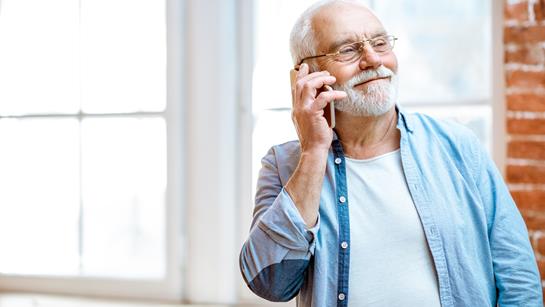 Older Man Smiling On The Phone At Home