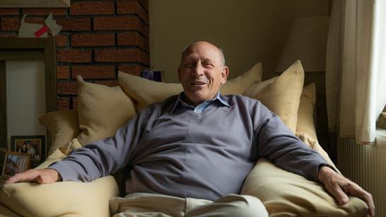 Older Man Sat On Armchair At Home Relaxed