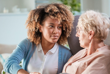 Two Women Talking Together On The Sofa