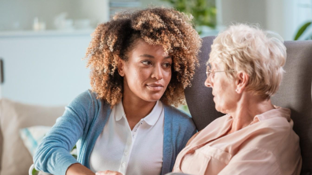 Two Women Talking Together On The Sofa